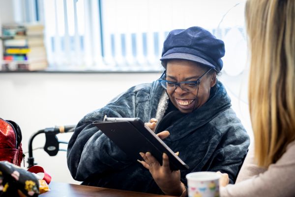 person on iPad smiling