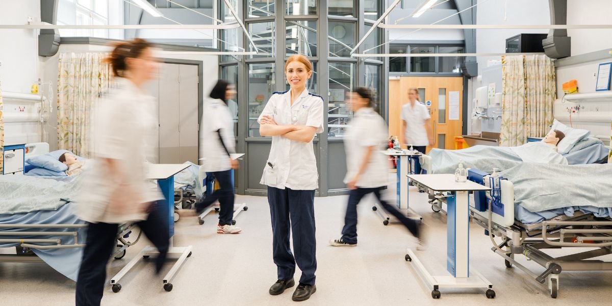 Student standing in a Nursing practical space.