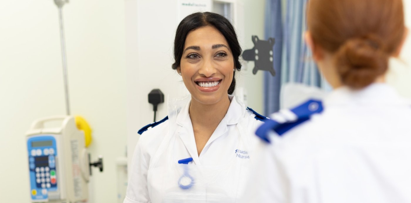 Two adult nursing students speak in the clinical skills suite
