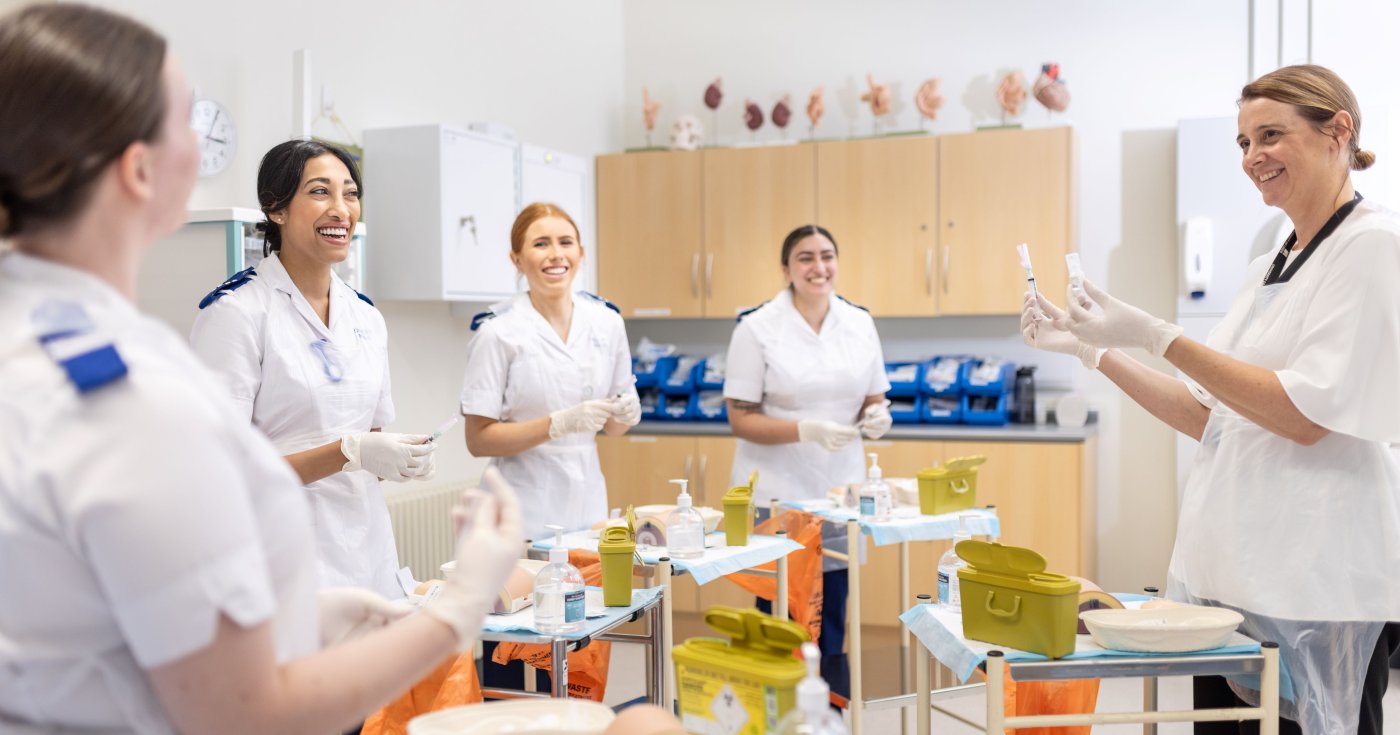 Adult Nursing students practising with a tutor in the clinical skills suite facilities