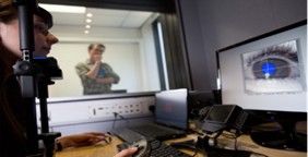 people watching a screen showing an image of an eye