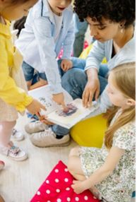 children reading a book with an adult