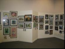 One wall of an art gallery, with framed images covering it