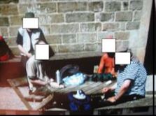 Four men sat on outside chairs. Their faces are covered by white squares.