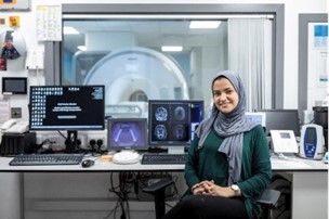 Licamm smiling female researcher in a headscarf sitting in front of machines
