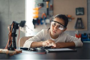 Girl at a desk in front of a fan
