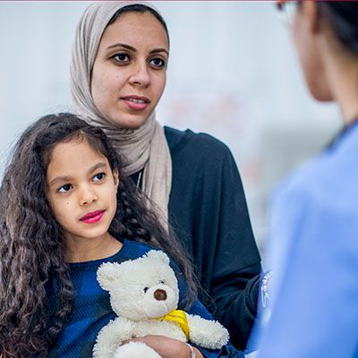 Mother and child talking to healthcare professional