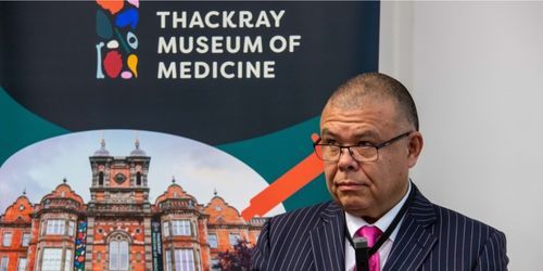 A speaker at the Monty Losowsky Memorial Lecture 2022 standing in front of a pull-up banner for the Thackray Memorial Hospiital