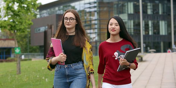 Two postgraduate students walking across campus at the University of Leeds.