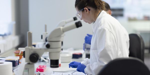 female researcher using a microscope