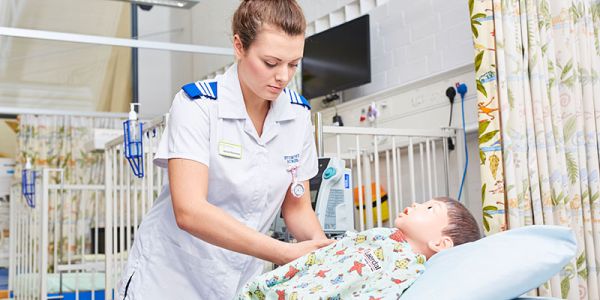 Healthcare child nursing student with simulation doll