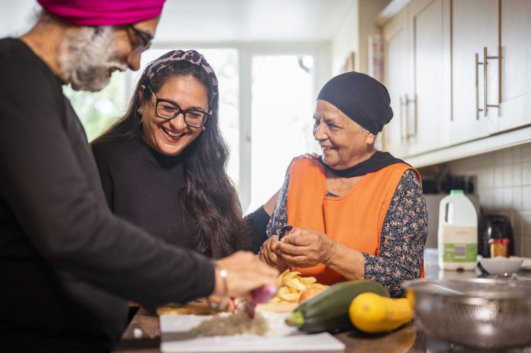 three people chopping vegetables