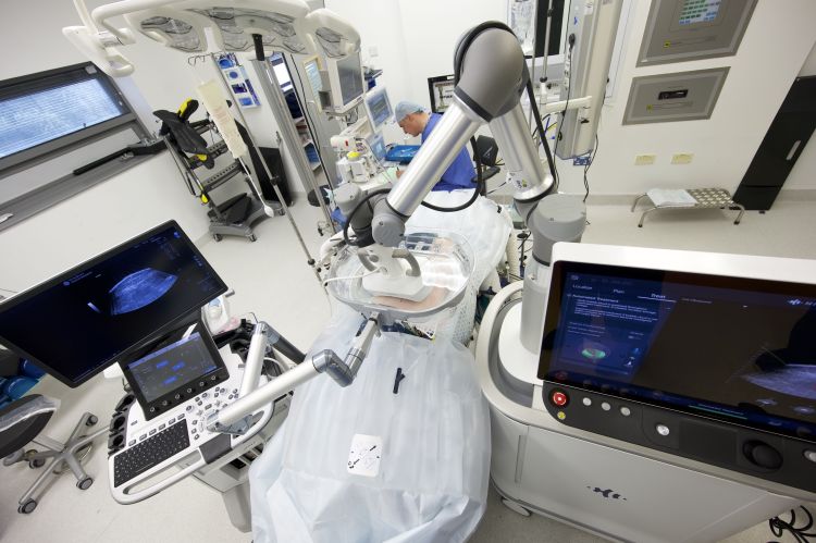 Overhead view of a clinical treatment room with HistoSonics Edison Therapy equipment positioned around a patient bed, alongside other medical equipment