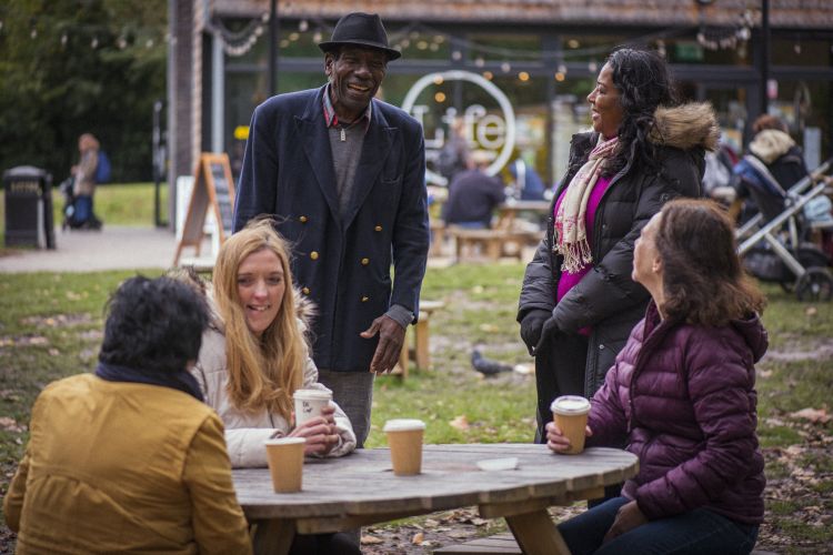 Variety of people talking around an outside table
