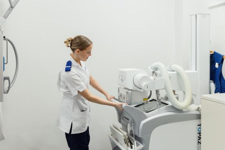 Female student operating radiography equipment.