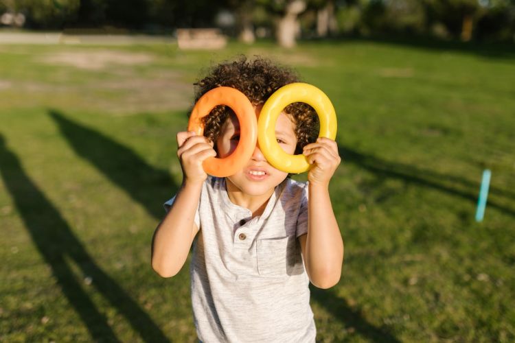 Boy holding small rings to his face