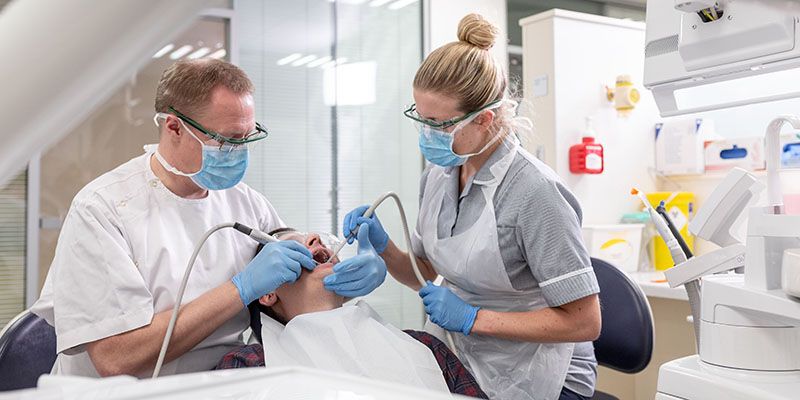 Dental professionals working in clinical suite