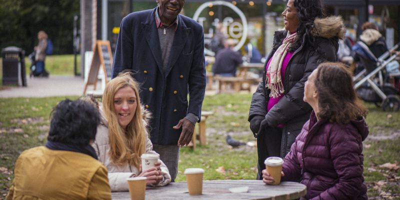 Variety of people talking around an outside table