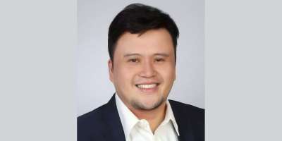 A portrait of Dr Melvin Sanicas smiling.