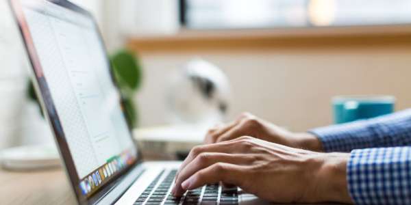 A side view of two hands typing on a laptop. 
Credit: Unsplash/Burst