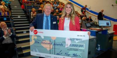 Jessica Jaffrey being presented a prize cheque for £1,000 by one of the judging panel in front of the audience of the Monty Lowosky Memorial Lecture