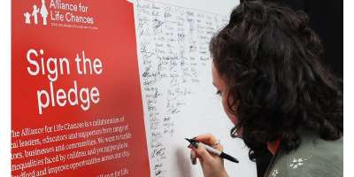 A woman signing the Alliance for Life Chances pledge card